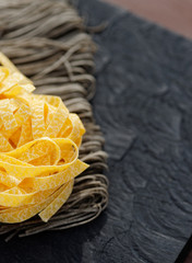 Two types of pasta on wooden plank