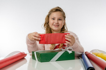Mädchen verpackt Weihnachtsgeschenke mit buntem Papier