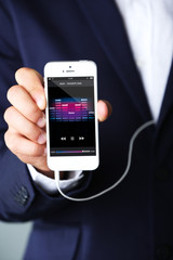 Music smartphone in businessman hand, close-up