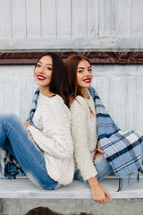 Two girls sit on a bench in the park