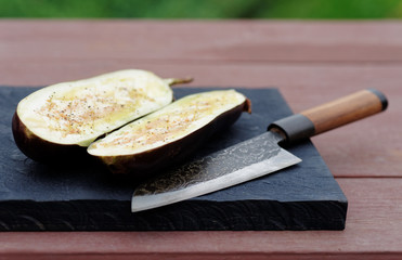 Eggplant prepared for grilling and old knife