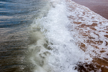 Crashing waves as they hit the sandy beach