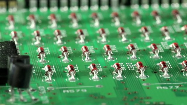 Microcircuit chip with electronic components. Close-up of micro circuit, resistors and chips. Chips and resistors on green circuit board close up. Close up of electronic circuit board, macro lens
