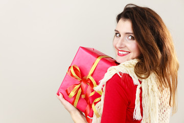 Woman with red gift box on gray.