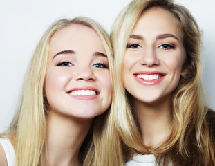 Two young girl friends standing together and having fun.
