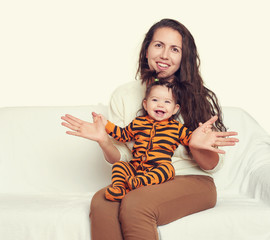 woman with child girl portrait sitting on sofa and playing