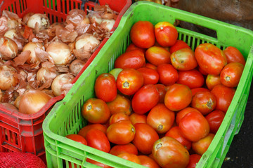 tomatoes and onions on plastic box from market
