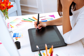 Artist drawing on graphic tablet in office