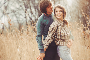 Fototapeta premium young happy loving couple walking on country field, cozy mood, rural scene