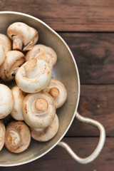 champignons portobello mushrooms in pan on a wooden background