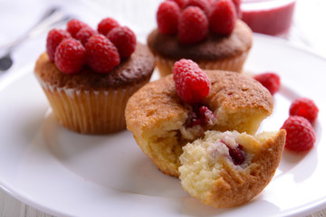 Delicious cupcakes with berries on plate close up