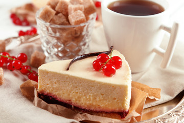 Tasty cheesecake with berries and cup of tea on table close up
