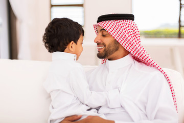 arabian father and son sitting at home