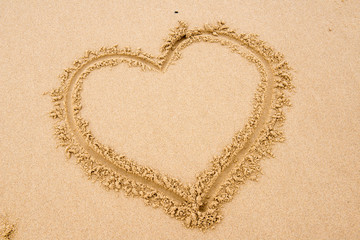 Heart shape drawn in the sand on a beach