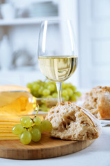 Still life of wine, grape, cheese and bread on light background