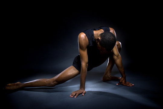 Black Male Dancer Practicing Warm Up Exercises For Flexibility