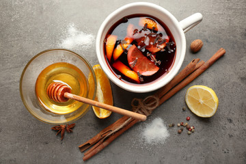 Tasty mulled wine in ceramic cup with citruses and cinnamon on the table