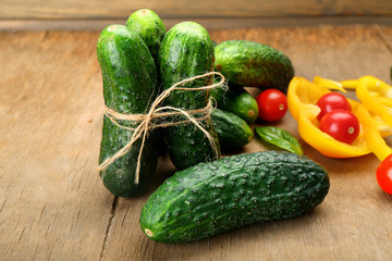 Composition of cucumbers, tomatoes and sweet peppers circles on wooden background