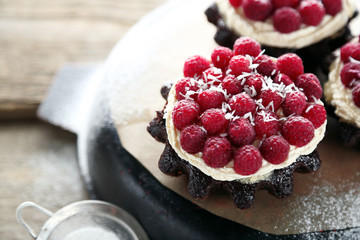 Sweet cakes with raspberries on wooden table background