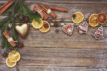 Christmas wooden background with Christmas cookies, heart, cinnamon and Christmas tree. Toned