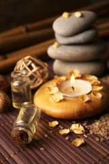 Decorated composition with candles and pebbles on bamboo mat, close up