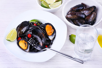 Cooked pasta, mussel and lime on white wooden background