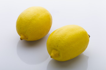 Two yellow lemon on a white background