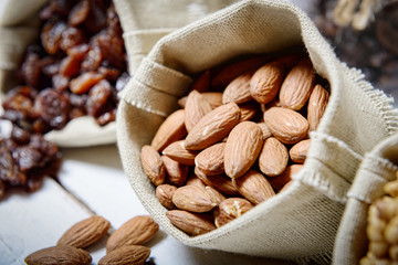 Almonds in small hessian bag, dried currants in background