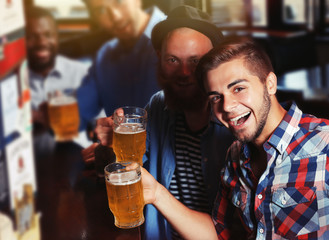 Young men drinking beer in pub