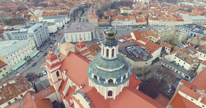 AERIAL. Smooth 360 flight around beautiful Church of St. Casimir in Vilnius old town, Lithuania. Panorama of Vilnius old town