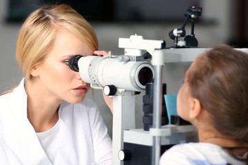 Fototapeta premium Adult female doctor examing small girl patient