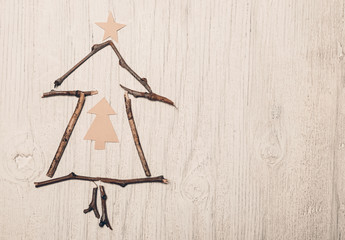 Christmas tree made of twigs on vintage wooden background and space for text