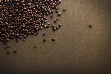 Roasted coffee beans on grey textile background