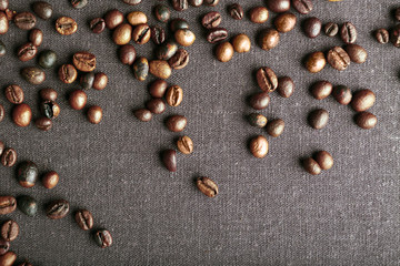 Roasted coffee beans on grey textile background