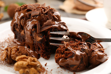 A piece of chocolate cake with walnut on the table, close-up