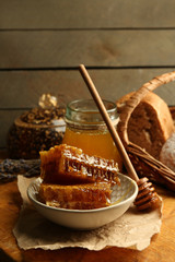 Honeycombs on plate, hot buns on wooden background