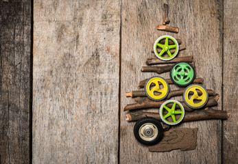 Christmass tree made of twigs and colorfull wheels on wooden background with copy space