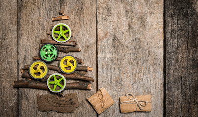 Christmass tree made of twigs and colorfull wheels on wooden background with copy space