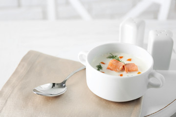 Delicious salmon cream soup on white served table in the restaurant