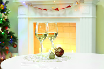 Champagne glasses with Christmas decor on fireplace background