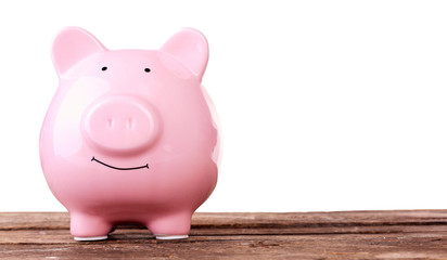 Piggy bank on wooden table against white background