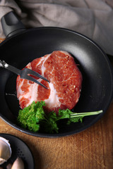 Marbled beef steak on pan and spices on wooden background