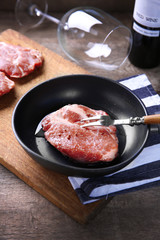 Marbled beef steak and wine bottle on wooden background