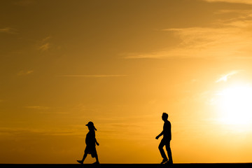 Silhouette people walking at sunset