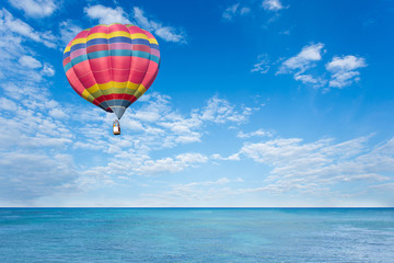 Fototapeta premium Colorful hot air balloon over blue sea