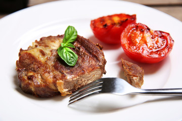 Roasted beef fillet on plate, on wooden background