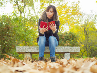 mujer leyendo en un parque en otoño