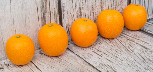 Kumquat fruit over wooden background