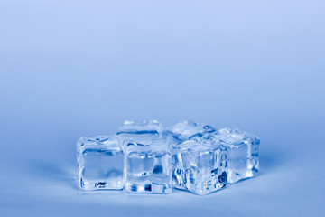Ice cubes on grey background (blue cooling style)