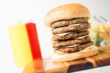 Mega cheeseburger with potato chips and ingredients on a white background